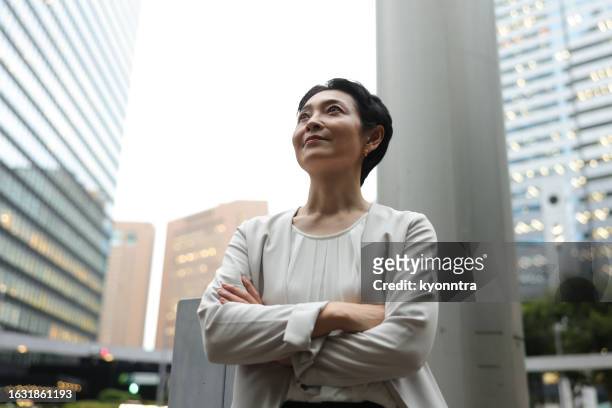 portrait of a middle-aged businesswoman looking up - japanese bussiness woman looking up imagens e fotografias de stock