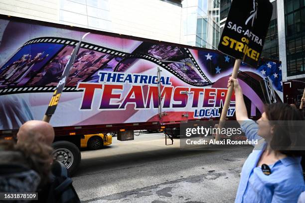 Theatrical Teamsters truck drives past members of the AFL-CIO, representing multiple unions, join members and supporters of the WGA and SAG-AFTRA on...