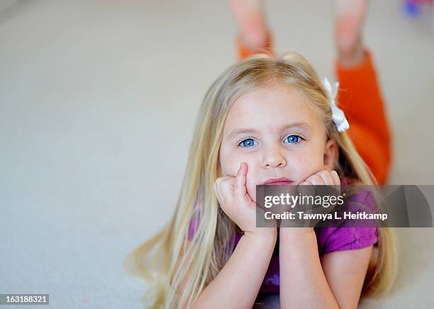 young blonde girl lays on floor with pensive look - fishers indiana stock pictures, royalty-free photos & images