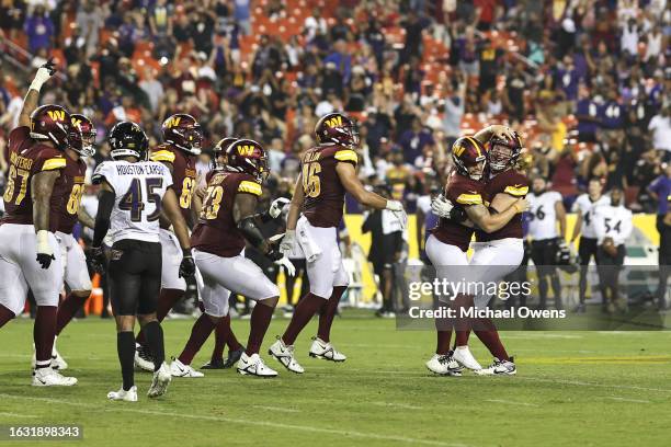 Joey Slye of the Washington Commanders celebrates with his teammates after kicking the game winning field goal against the Baltimore Ravens during an...