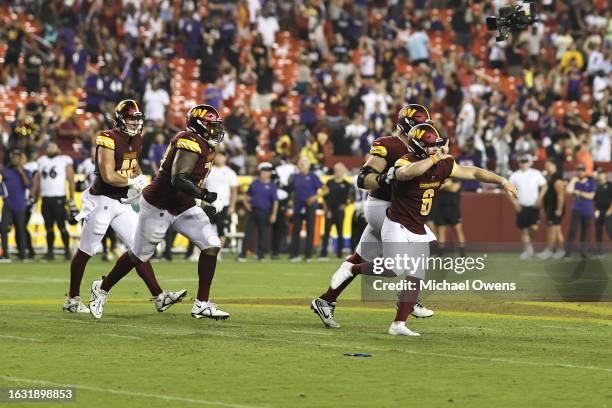 Joey Slye of the Washington Commanders celebrates with his teammates after kicking the game winning field goal against the Baltimore Ravens during an...