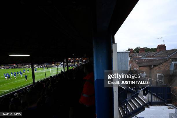 Supporters arrive as Gillingham's team players warm up prior to the start of the English League Cup football match between Luton Town and Gillingham...