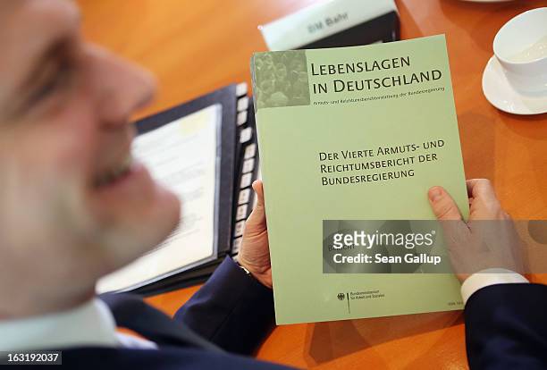 German Health Minister Daniel Bahr holds the "4th Poverty And Wealth Report of the Federal Government" during the weekly German government cabinet...