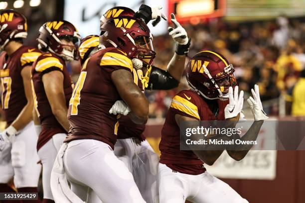 Dyami Brown of the Washington Commanders celebrates after completing a pass for a touchdown against the Baltimore Ravens during an NFL preseason game...