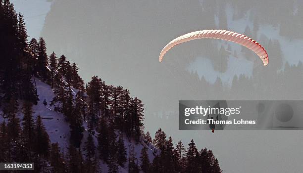Paraglider sails at sunset from the mountain Nebelhorn to the valley in Oberstdorf on March 4, 2013 in Oberstdorf, Germany. The remarkable nature...