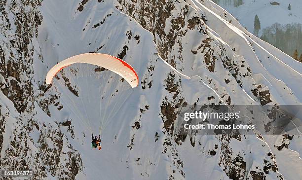 Paraglider sails at sunset from the mountain Nebelhorn to the valley in Oberstdorf on March 4, 2013 in Oberstdorf, Germany. The remarkable nature...