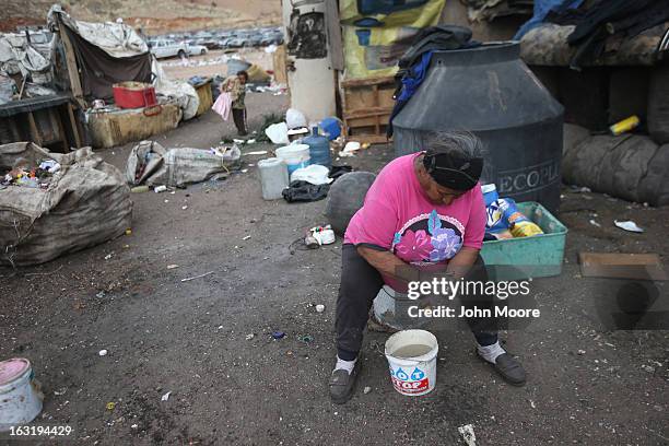 Dona Petra washes her hands in front of her modest home inside the Tirabichi garbage dump on March 5, 2013 in Nogales, Mexico. About 30 families,...