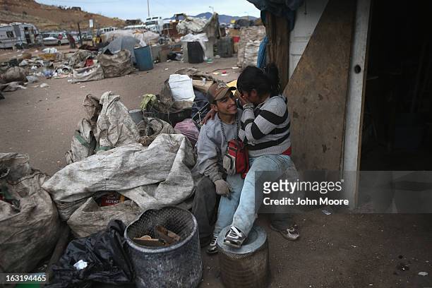 Clara Janet Morales and Omar Guzman embrace while waiting to purchase recyclables scavenged by workers at the Tirabichi garbage dump on March 5, 2013...
