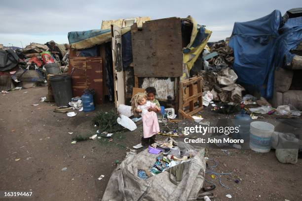 Mirna Guadelupe plays in front of her modest home with a doll found at the Tirabichi garbage dump on March 5, 2013 in Nogales, Mexico. About 30...