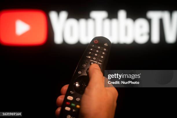 The YouTube TV logo is seen displayed on a screen with a hand holding a remote control in this illustration photo taken in Warsaw, Poland on 29...