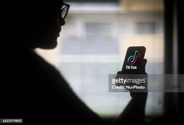 The TikTok logo is seen on a mobile device held in the hand of a man with glasses in this illustration photo in Warsaw, Poland on 29 August, 2023.
