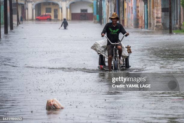 Man rides a tricycle through a flooded street in Havana, on Augusto 29 during the passage of tropical storm Idalia. Tropical Storm Idalia...