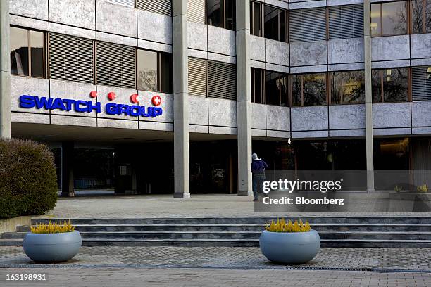 Visitor walks towards the entrance of Swatch AG's headquarters in Bienne, Switzerland, on Wednesday, March 6, 2013. Swatch Group AG, the biggest...