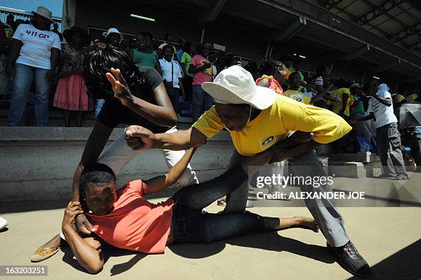 People reenact the way the police treated Mido Macia, a Mozambican man who died in custody after being dragged behind a South African police van,...