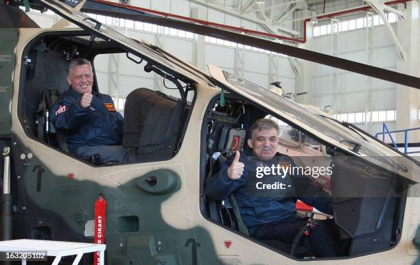 Jordan's King Abdullah II and Turkey's President Abdullah Gul wearing Turkish Air Force pilot jackets, pose inside a Turkey-made Atak helicopter at...