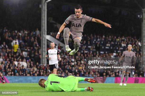 Giovani Lo Celso of Tottenham Hotspur jumps over Fulham goalkeeper Marek Rodak during the Carabao Cup Second Round match between Fulham and Tottenham...