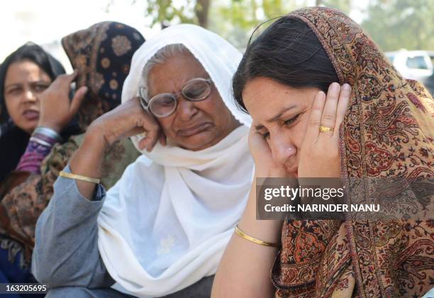 Simrjeet Kaur the wife of late Indian Punjab Police assistant sub-inspector Kulbir Singh and his mother Kailash Kaur mourn after his death outside a...