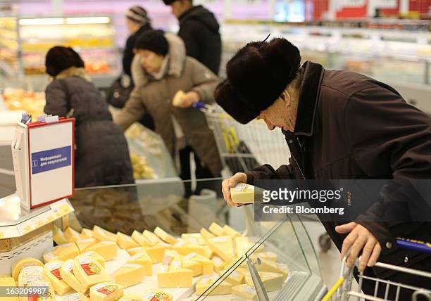 Customer selects cheese from a counter inside a Lenta LLC supermarket in Prokopyevsk, Kemerevo region, Russia, on Wednesday, March 6, 2013. Lenta...