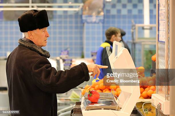 Customer uses an electronic scale to weigh and price a red pepper inside a Lenta LLC supermarket in Prokopyevsk, Kemerevo region, Russia, on...