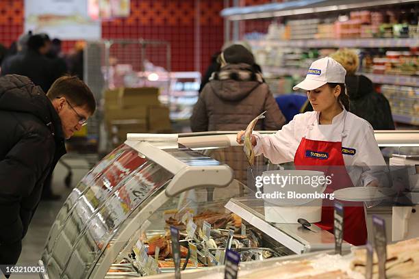 Customer browses while an employee restocks the fresh fish counter inside a Lenta LLC supermarket in Prokopyevsk, Kemerevo region, Russia, on...