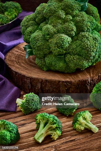 fresh organic broccoli in an basket on rustic wooden table. - brokkoli stock-fotos und bilder