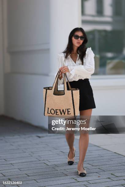 Milena Karl is seen wearing black sunglasses from Chanel, a gold necklace, a white shirt with puffy sleeves from Isabel Marant, a large tote bag from...