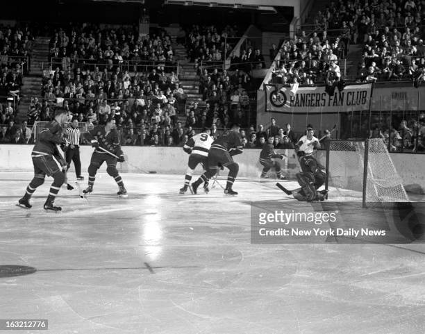 Detroit Red Wings Gordie Howe is wide with his shot as New York Ranger Jim Nielson rides him off at Garden. Blues' goalie Jacques Plante moves in...