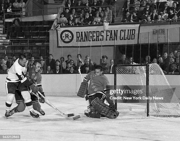 New York Rangers' goalie Marcel Paille smothers shot by Detriut Red Wings' Gordie Howe, who is tied up by defenseman Harry Howell, after first-period...