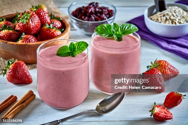 delicious and fresh strawberry smoothies on rustic wooden table. - batido de fresa fotografías e imágenes de stock