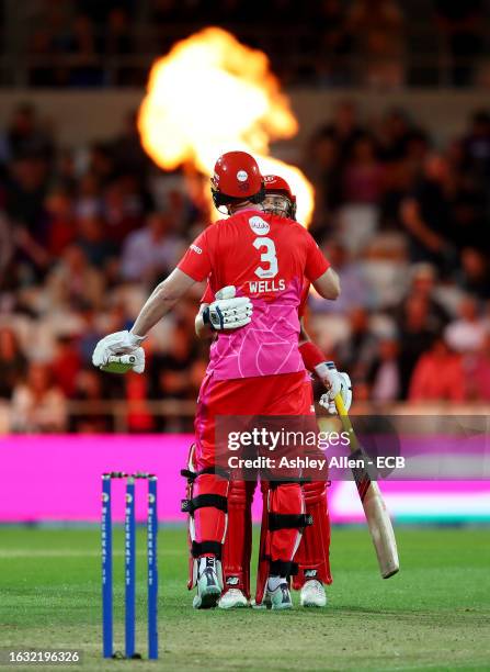 Luke Wells celebrates with teammate Joe Clarke of Welsh Fire after defeating Northern Superchargers during The Hundred match between Northern...
