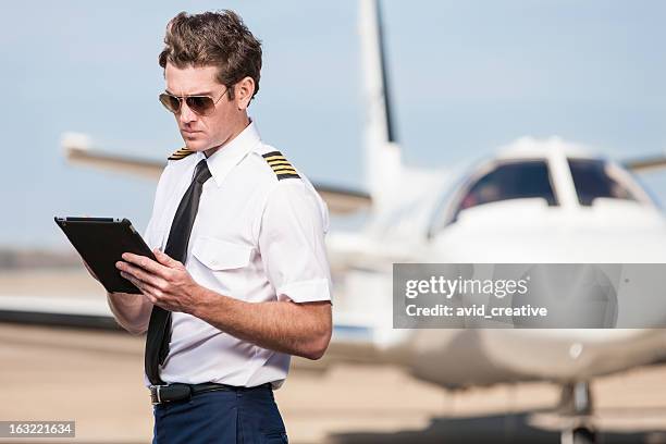 corporate pilot using electronic tablet - aviatrice stock pictures, royalty-free photos & images