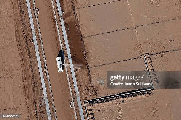 Truck sprays water on empty parcels of land at a new housing development on March 6, 2013 in Mesa, Arizona. In 2008, Phoenix, Arizona was at the...