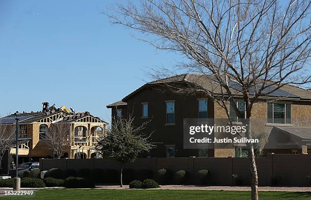 Laborers work on the roof of a new home under construction at a housing development on March 6, 2013 in Gilbert, Arizona. In 2008, Phoenix, Arizona...