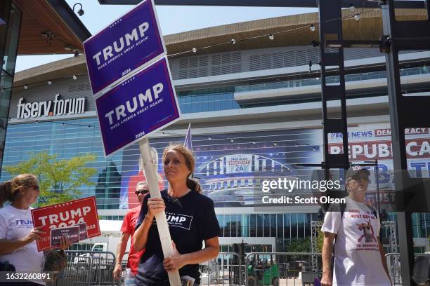 Supporters of Republican presidential candidate former President Donald Trump carry signs around the Fiserv Forum on August 22, 2023 in Milwaukee,...