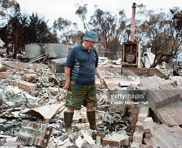 homeowner amongst ruins of burnt house - ruined photos et images de collection