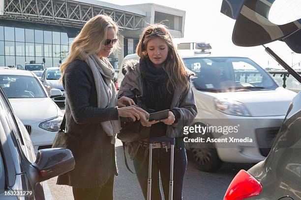 mother and daughter check travel documents,airport - airport parking stock-fotos und bilder