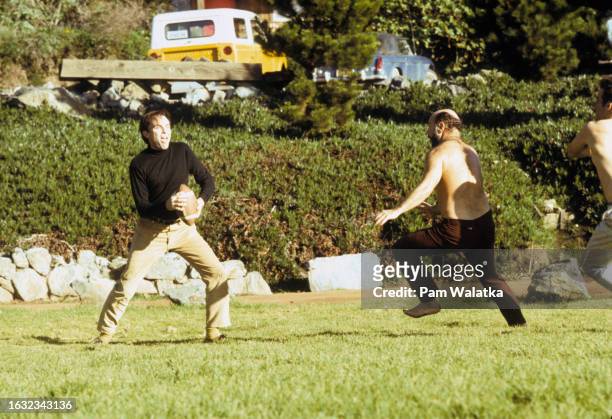 During a touch-football game, Esalen Institute co-founder Micheal Murphy looks to pass the ball as psychologist Will Schutz tries to tag him, Big...