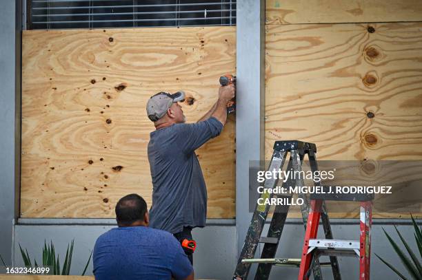 People board up a window in Tampa, Florida, on August 29, 2023 as the city prepares for Hurricane Idalia. Hurricane Idalia intensified Tuesday as it...