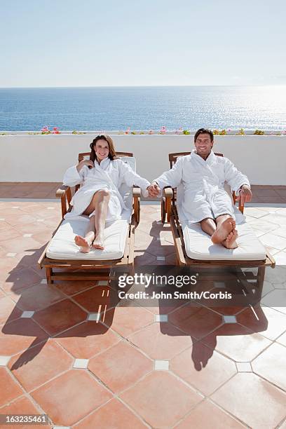 couple relaxing on sun loungers - hands sun stock-fotos und bilder