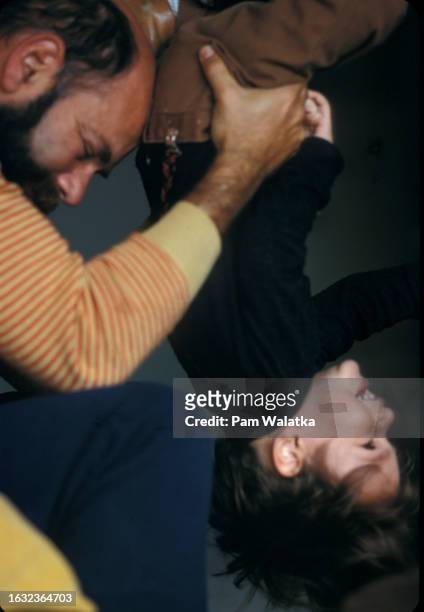American psychologist Will Schutz holds his smiling son, Ethan, upside down at the Esalen Institute, Big Sur, California, 1969. The institute was...
