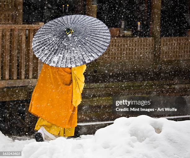 a buddhist monk walks through a snow flurry in koyasan, a centre for shingon esoteric buddhism. - koya san stock pictures, royalty-free photos & images