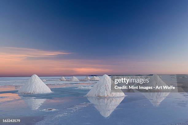 bolivia, salar de uyuni salt flats. piles of white salt crystals. harvesting the natural minerals. sunrise. - bolivia stock pictures, royalty-free photos & images