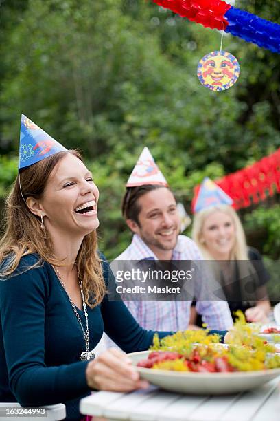 happy young woman with friends at dining table celebrating crayfish party - crawfish stockfoto's en -beelden