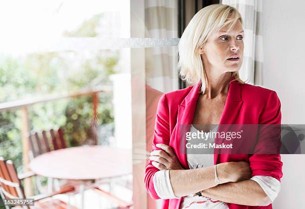 mature businesswoman with arms crossed standing at office - anger stock pictures, royalty-free photos & images