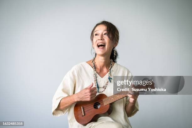sing song woman ukulele - woman playing acoustic guitar stock pictures, royalty-free photos & images