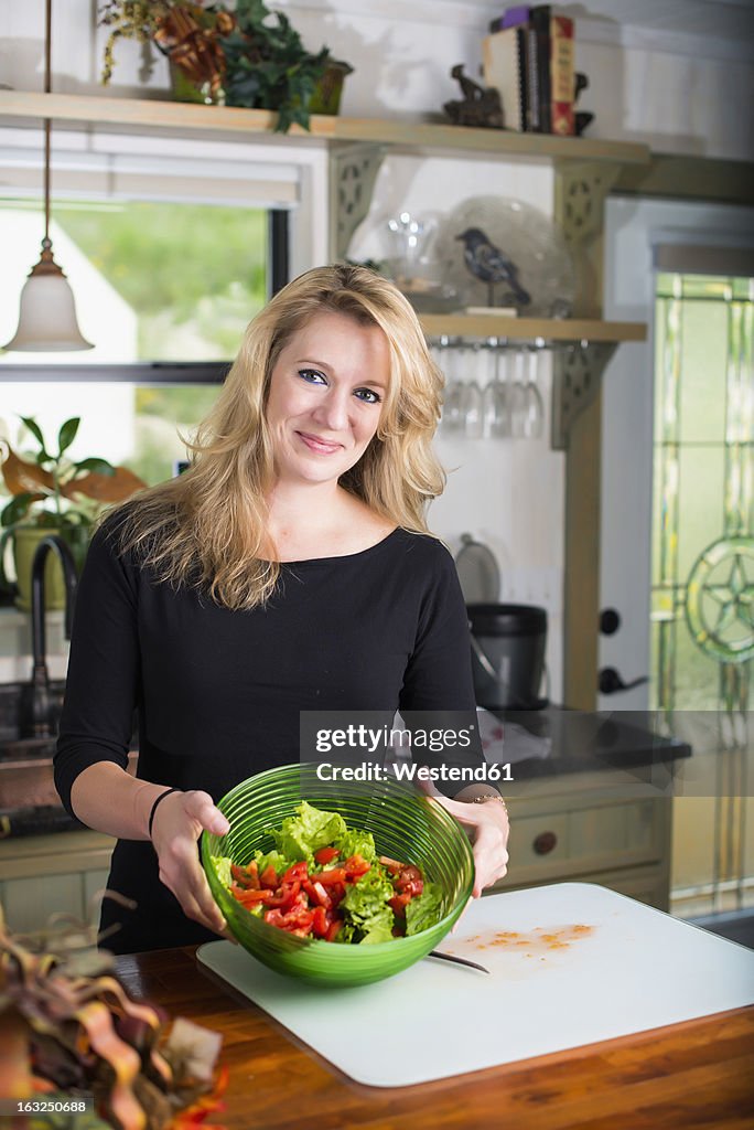 USA, Texas, Mid adult woman with salad bowl, smiling, portrait