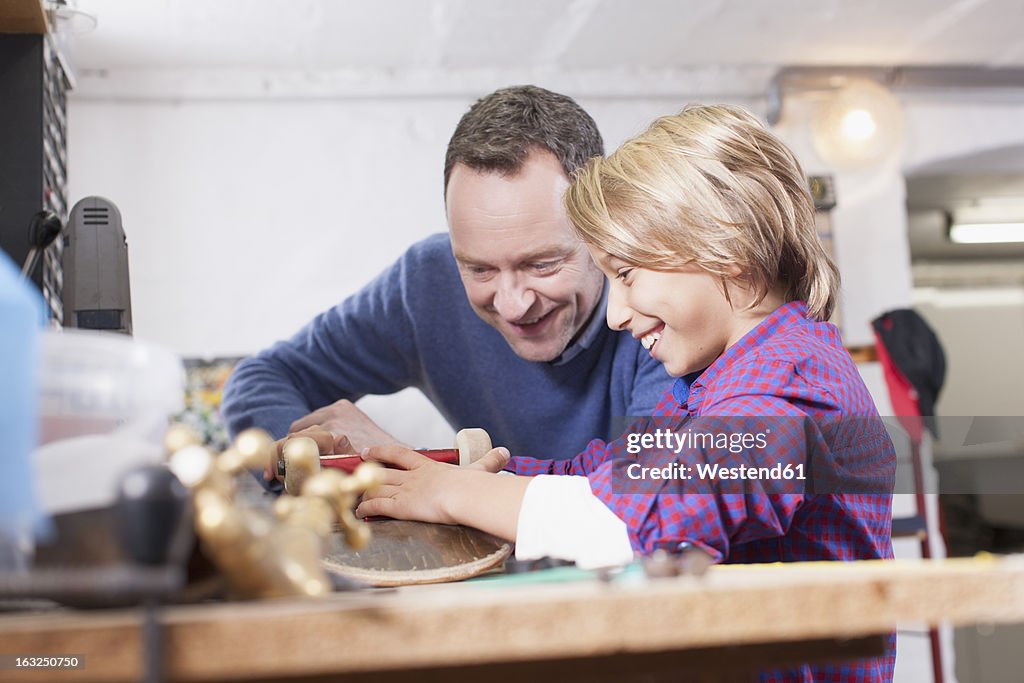 Germany, Leipzig, Father and son repairing skateboard