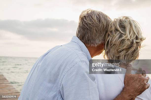 spain, senior couple standing at the sea - couple back stock pictures, royalty-free photos & images