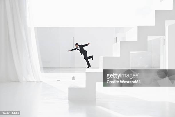 spain, businessman falling down from ladders - inciampare foto e immagini stock