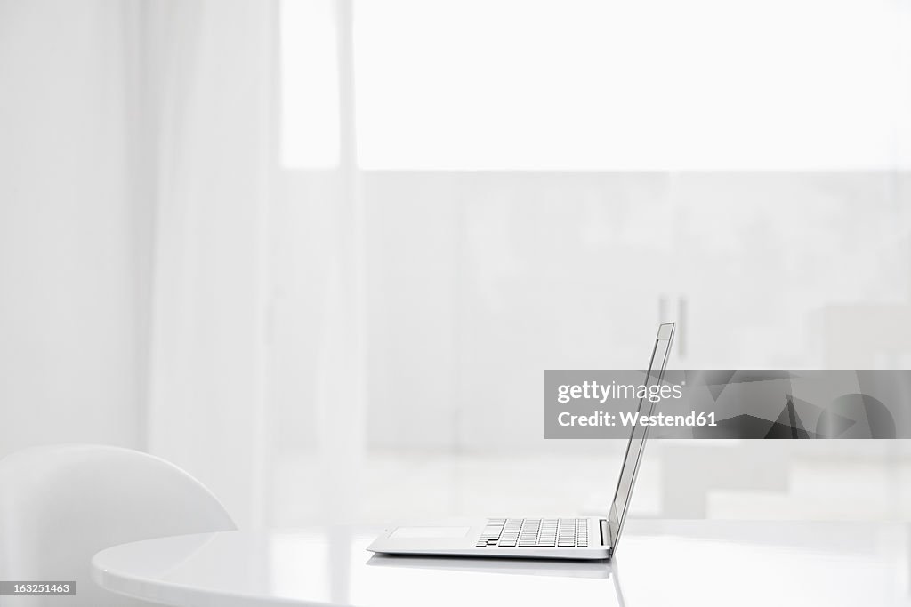 Spain, Modern living room with laptop and stairs